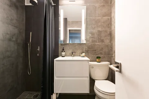 a white toilet sitting next to a bathroom sink