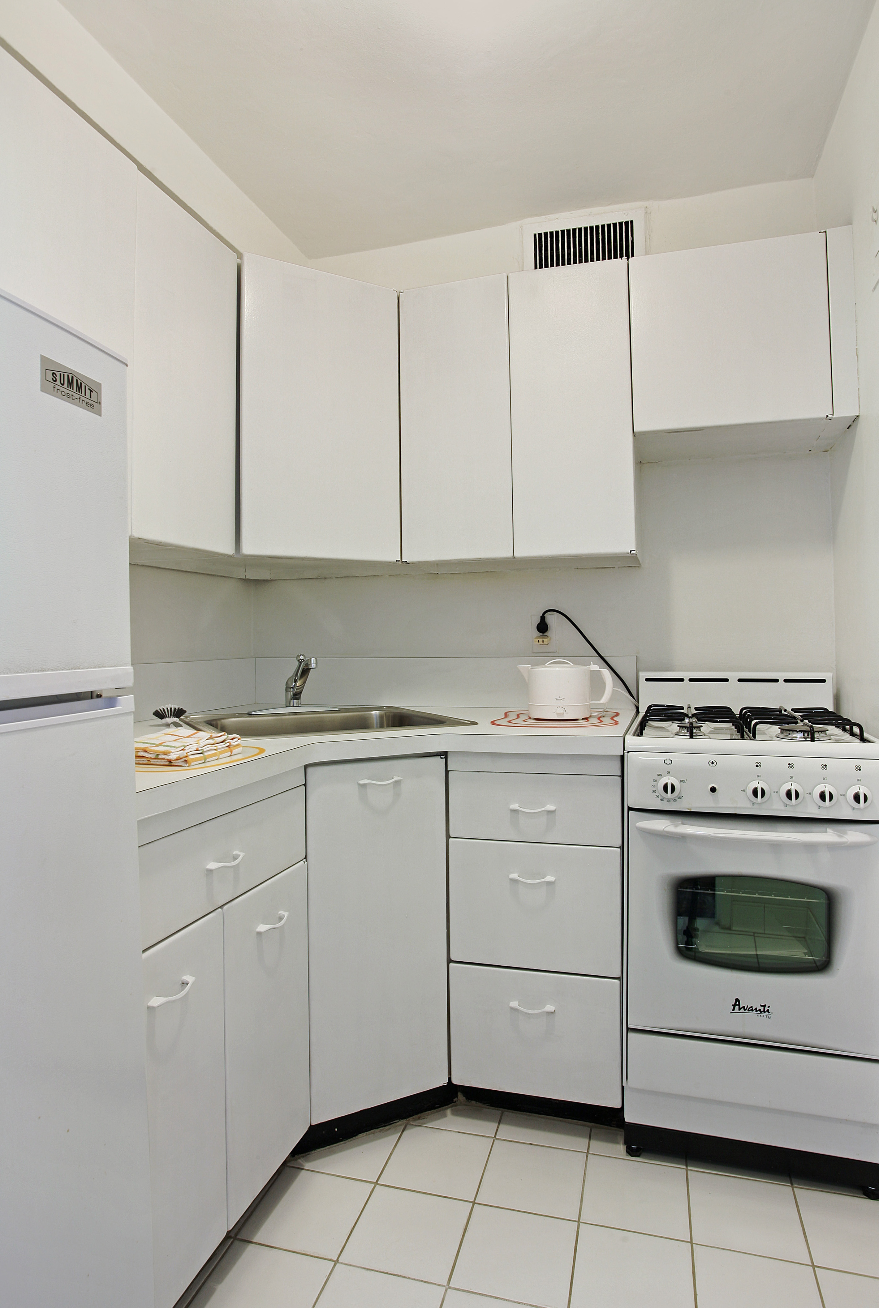 321 East 48th Street, Unit 7F Manhattan, NY 10017 - Photo 5 of 7 a utility room with cabinets washer and dryer