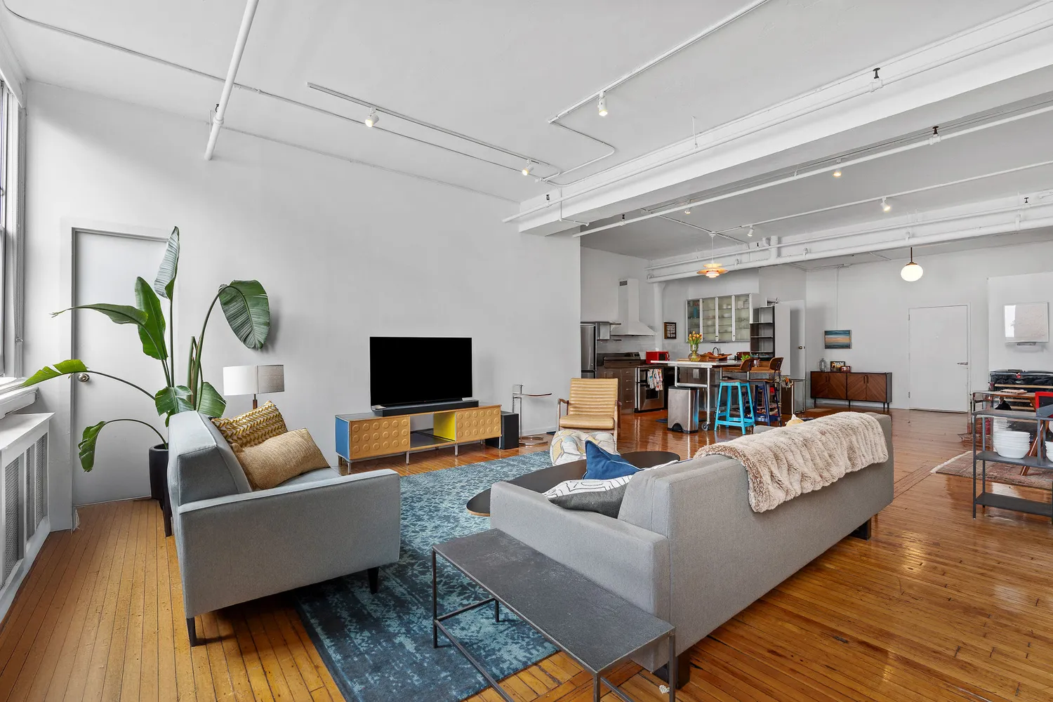 a living room with lots of furniture and wooden floor