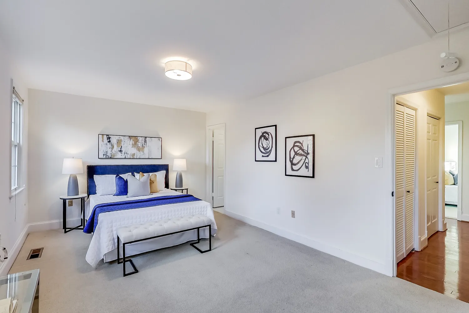 a bedroom with a bed and paintings on the wall