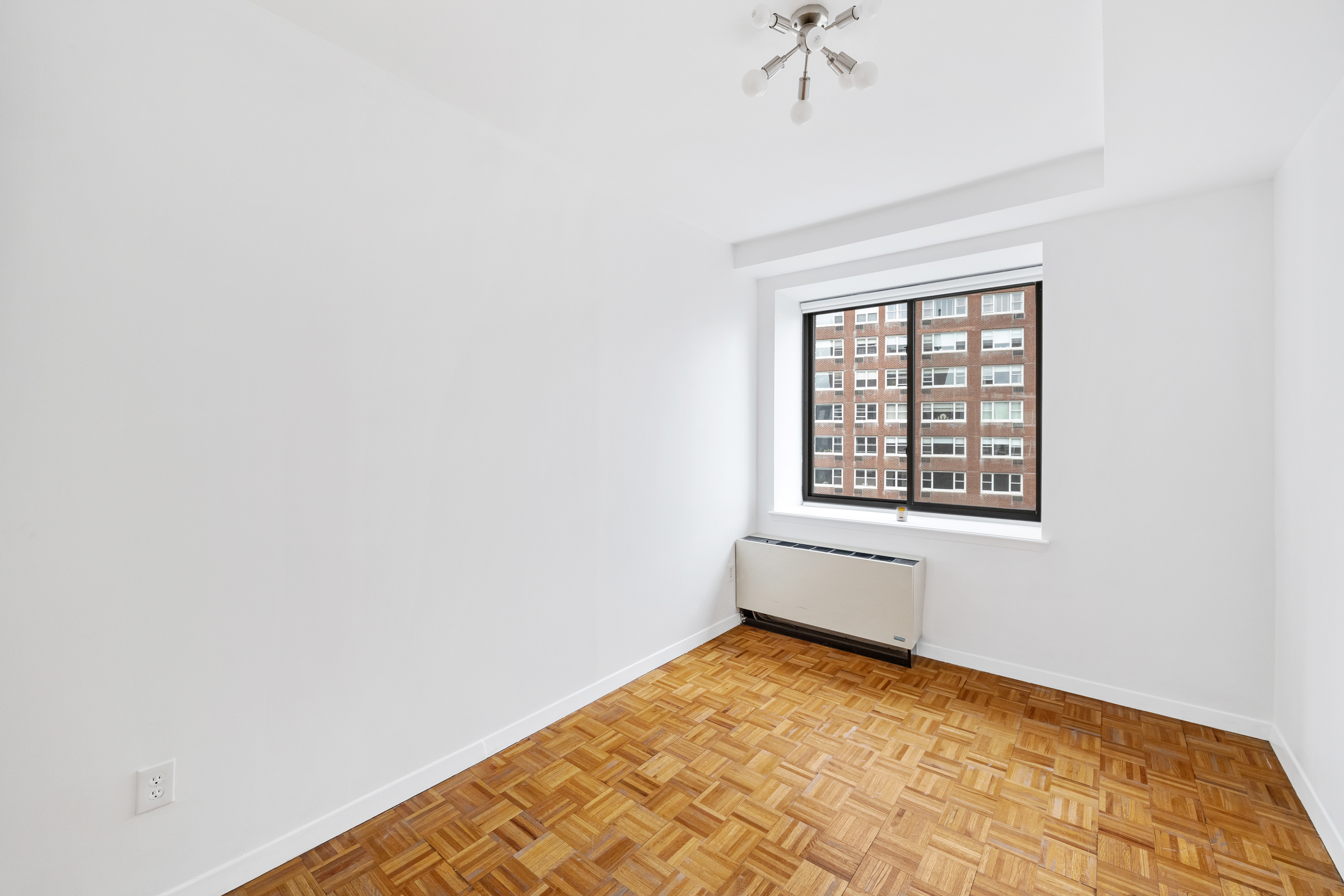 196 6th Avenue, Unit 5A Manhattan, NY 10013 - Photo 11 of 12 an empty room with a chandelier fan and windows