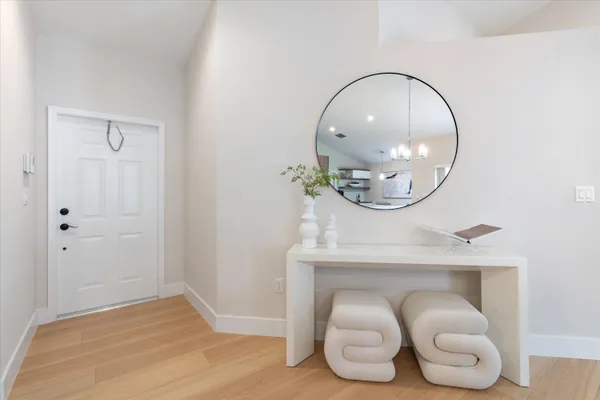 a dining room with wooden floor a glass table and chairs