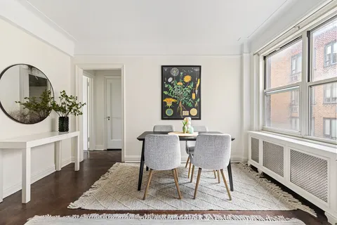 a dining room with furniture a rug and wooden floor