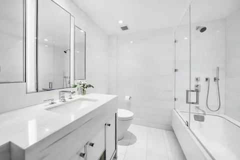a bathroom with a double vanity sink toilet and shower
