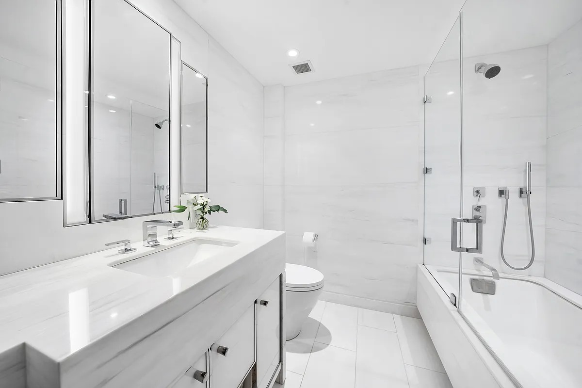 12 East 88th Street, Unit 6C Manhattan, NY 10128 - Photo 7 of 15 a bathroom with a double vanity sink toilet and shower