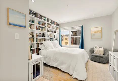 a bedroom with a bed and a book shelf