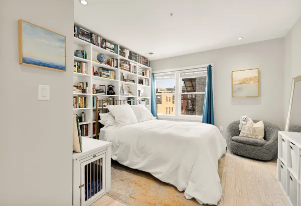 a bedroom with a bed and a book shelf