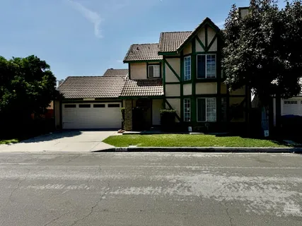 a front view of a house with a yard and trees