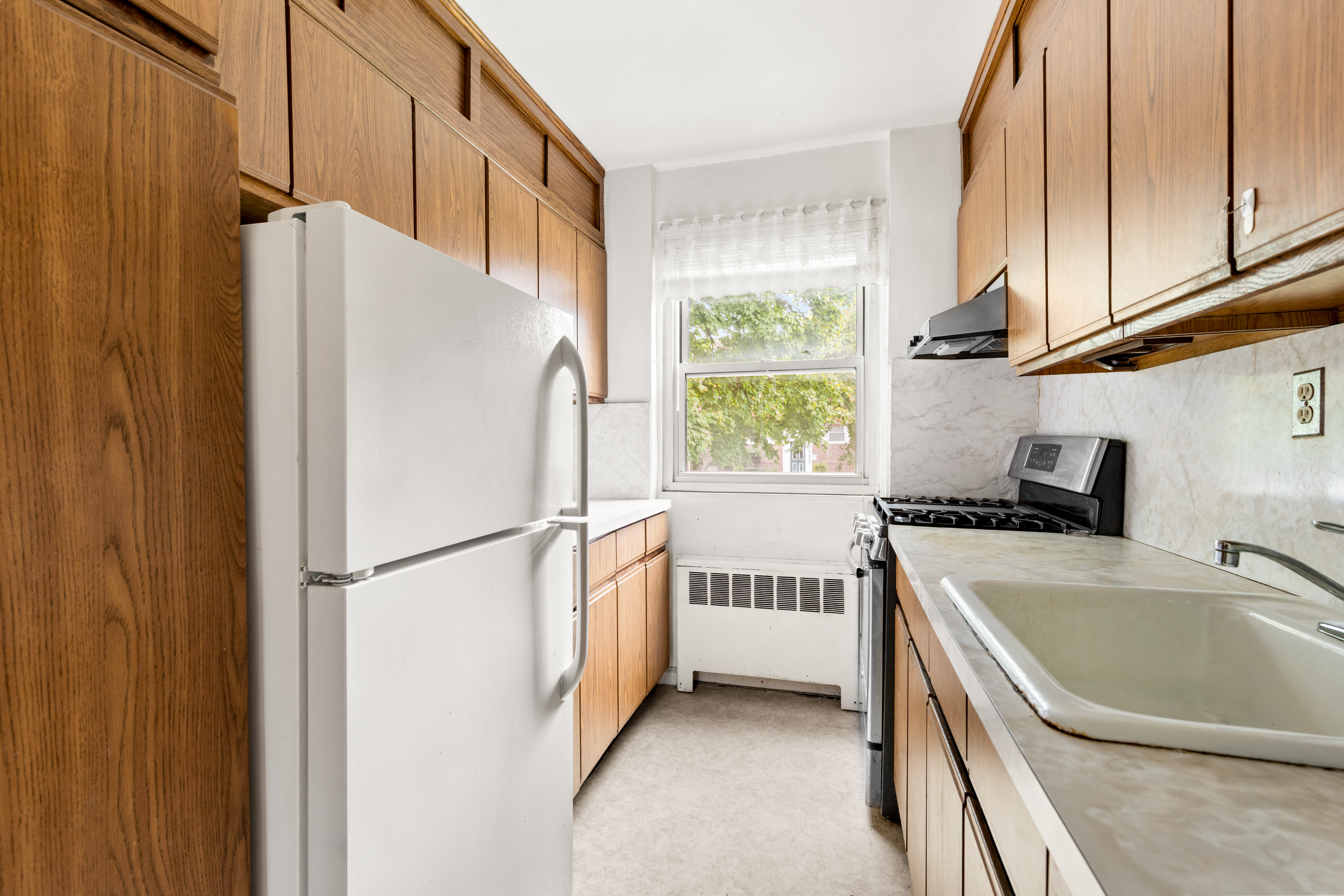 155-21 89th Street, Unit 2 Queens, NY 11414 - Photo 4 of 6 a white refrigerator freezer sitting inside of a kitchen