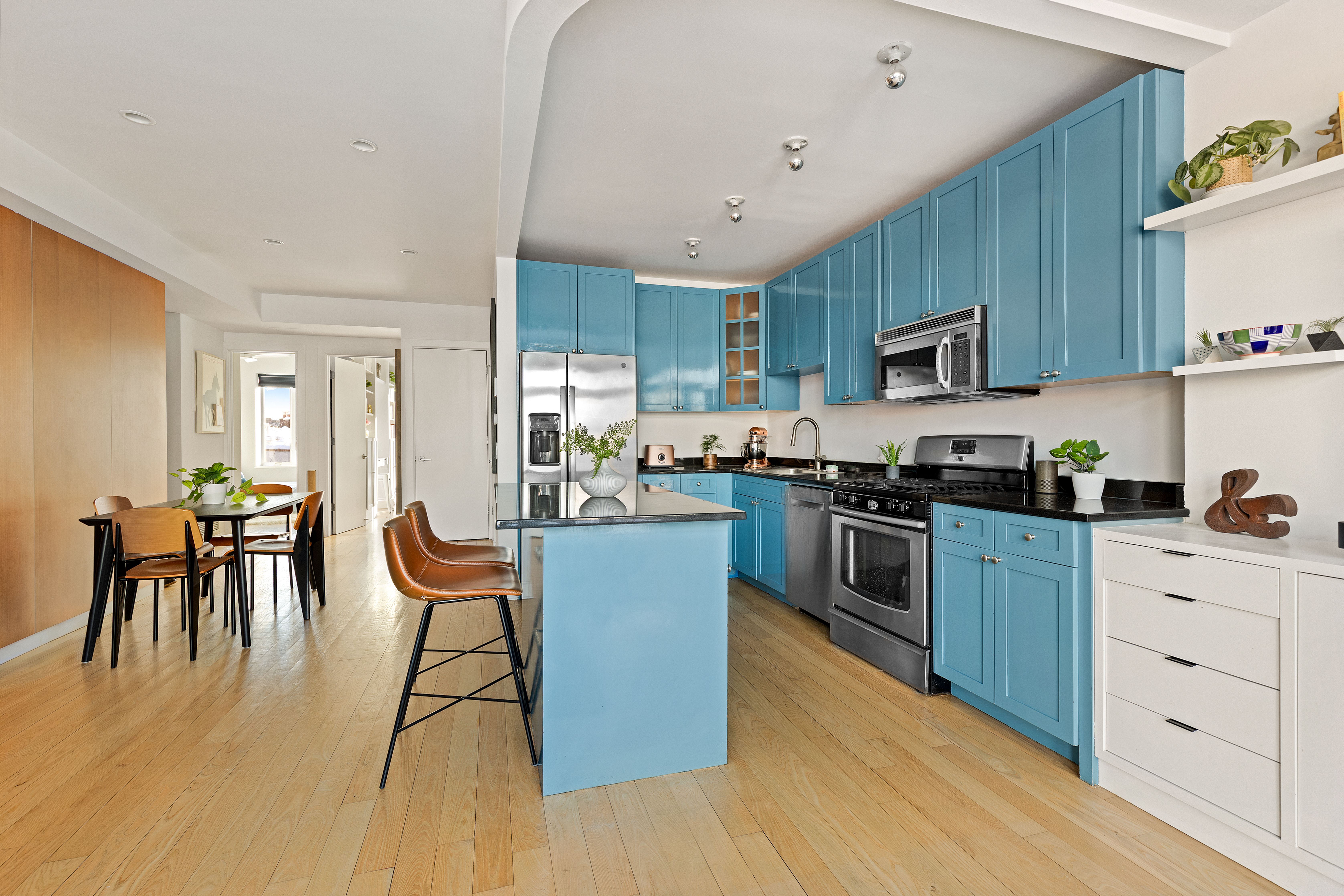 316 2nd Street, Unit 5E Brooklyn, NY 11215 - Photo 4 of 11 a kitchen with stainless steel appliances kitchen island granite countertop a table chairs microwave and sink