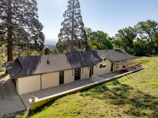 aerial view of a house with a yard and sitting area