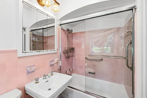 a bathroom with a sink mirror and shower