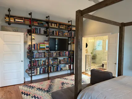 a bedroom with furniture and a book shelf