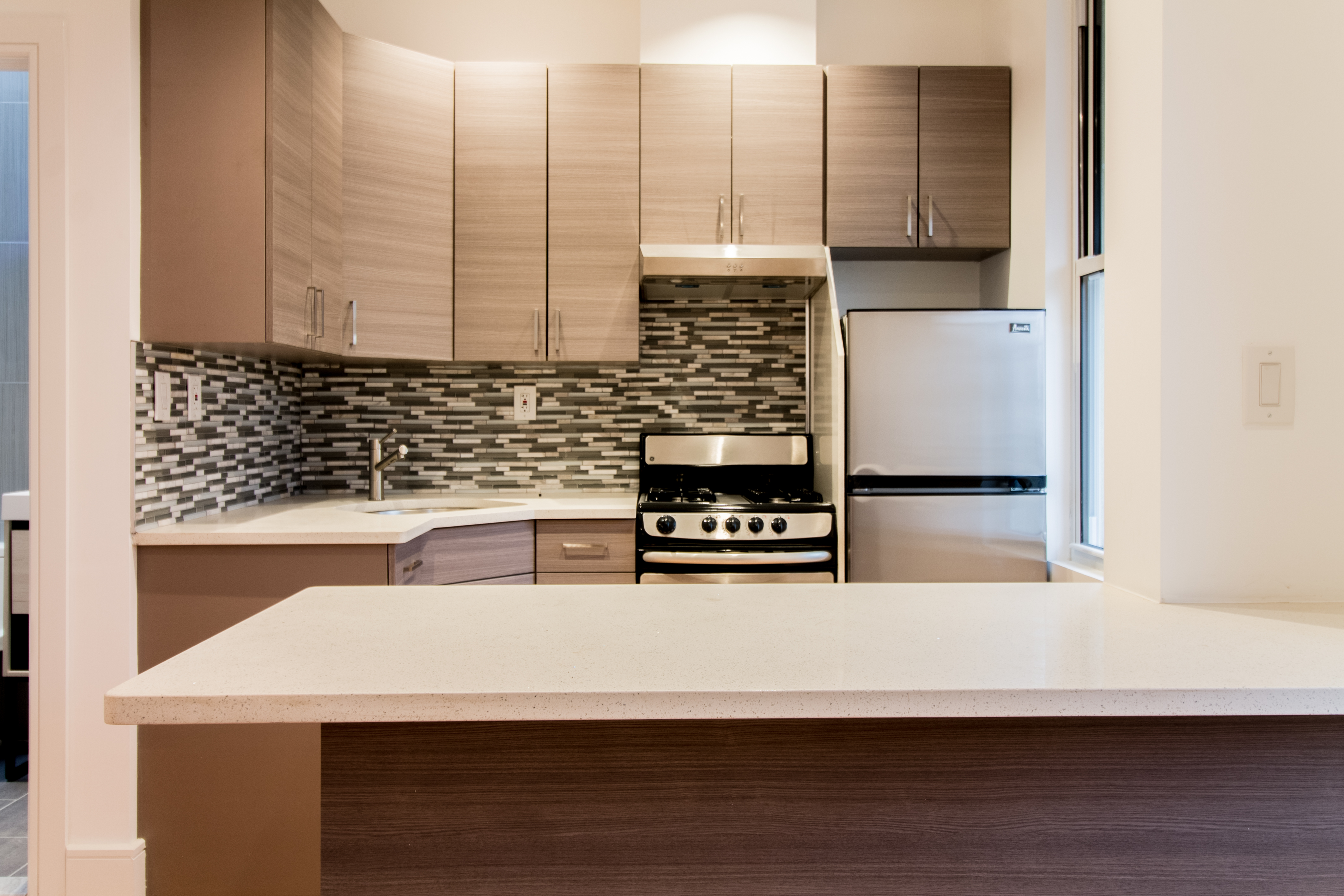 1923 Cornelia Street, Unit 2F Queens, NY 11385 - Photo 5 of 9 a kitchen with a sink a stove and a microwave