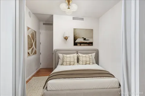 a bedroom with a bed and a chandelier