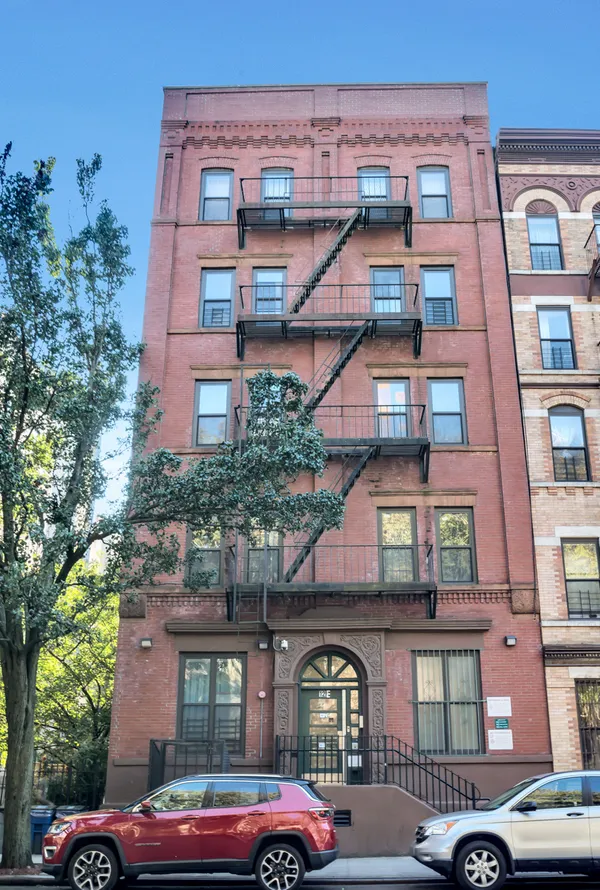 a front view of a residential apartment building with a yard