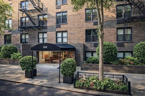 a front view of a building with a garden and plants