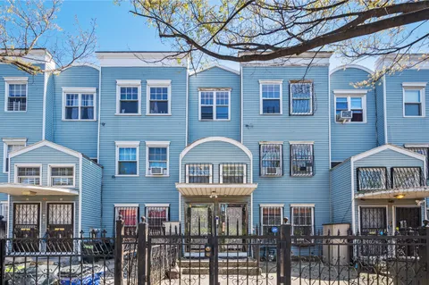 a front view of a residential apartment building with a yard