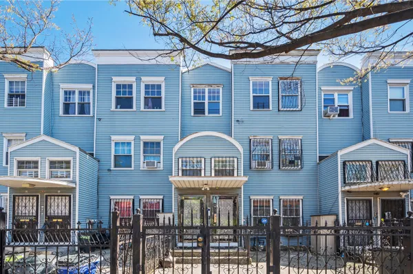 a front view of a residential apartment building with a yard