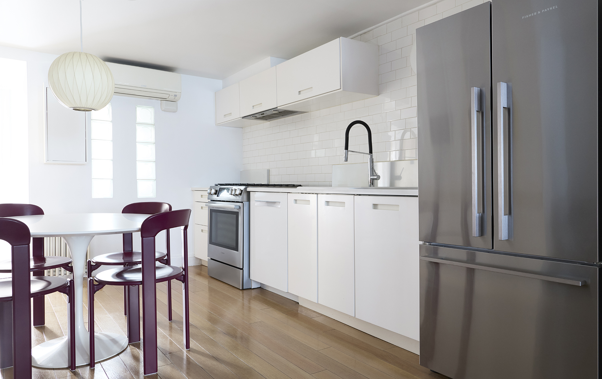 967 Lorimer Street, Unit 1 Brooklyn, NY 11222 - Photo 6 of 17 a kitchen with stainless steel appliances a refrigerator a table chairs and wooden floor