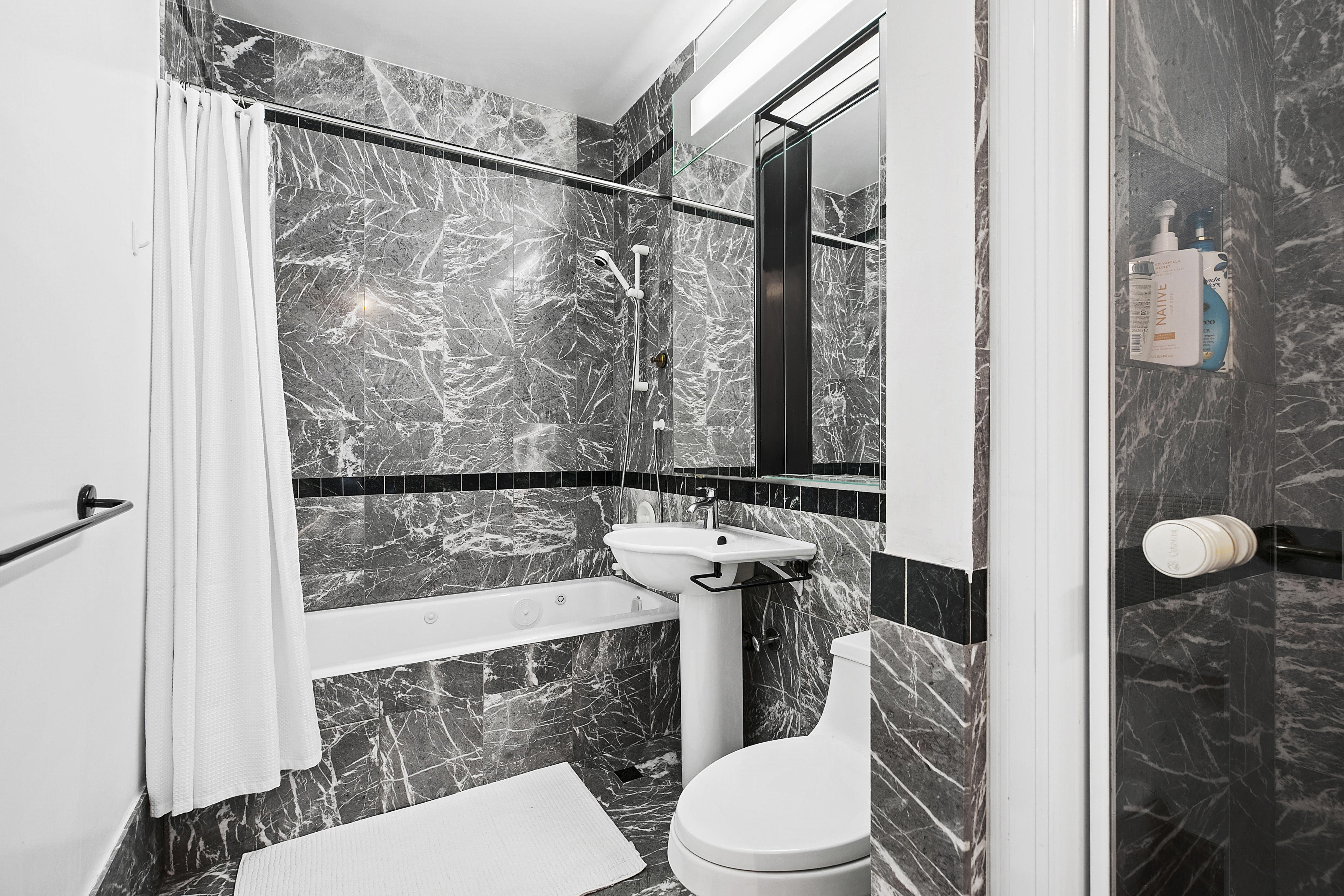 250 East 54th Street, Unit 6A Manhattan, NY 10022 - Photo 6 of 13 a bathroom with a toilet a sink and a shower