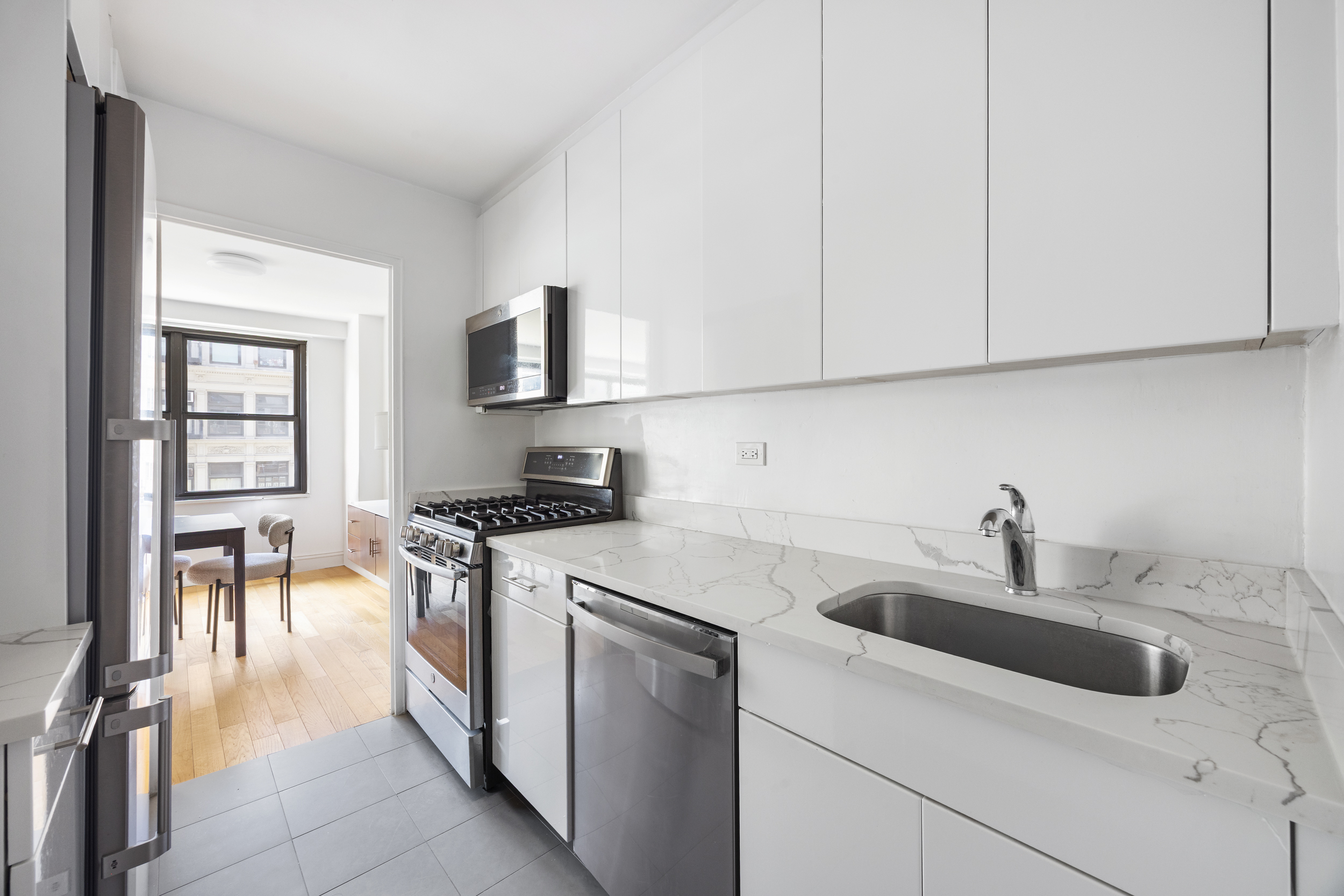 7 East 14th Street, Unit 605 Manhattan, NY 10003 - Photo 5 of 8 a kitchen with stainless steel appliances granite countertop a sink stove and cabinets