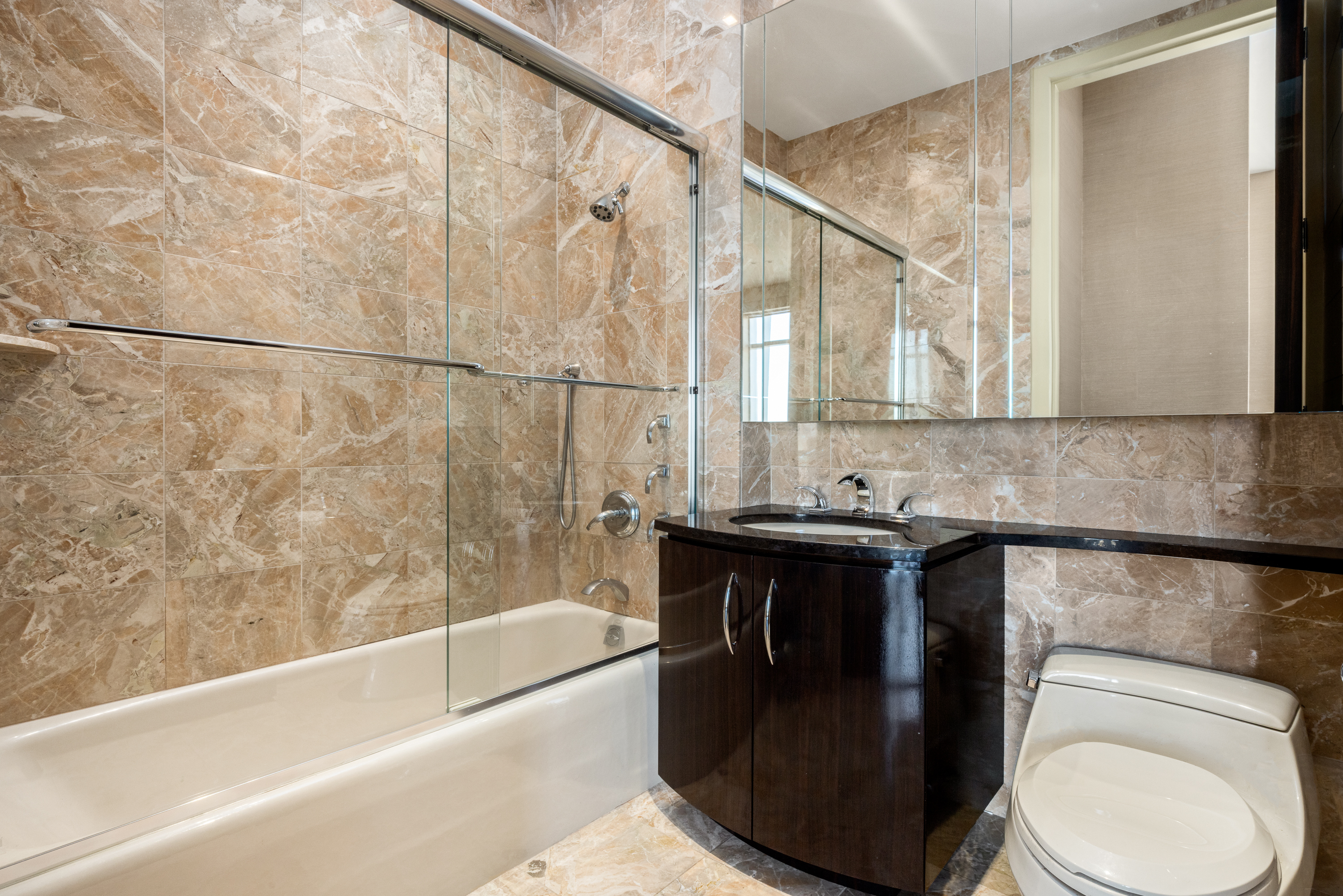845 United Nations Plaza, Unit 86B Manhattan, NY 10017 - Photo 13 of 16 a bathroom with a granite countertop sink toilet and bathtub
