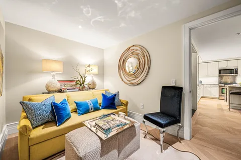 a living room with furniture a clock on wall and a table