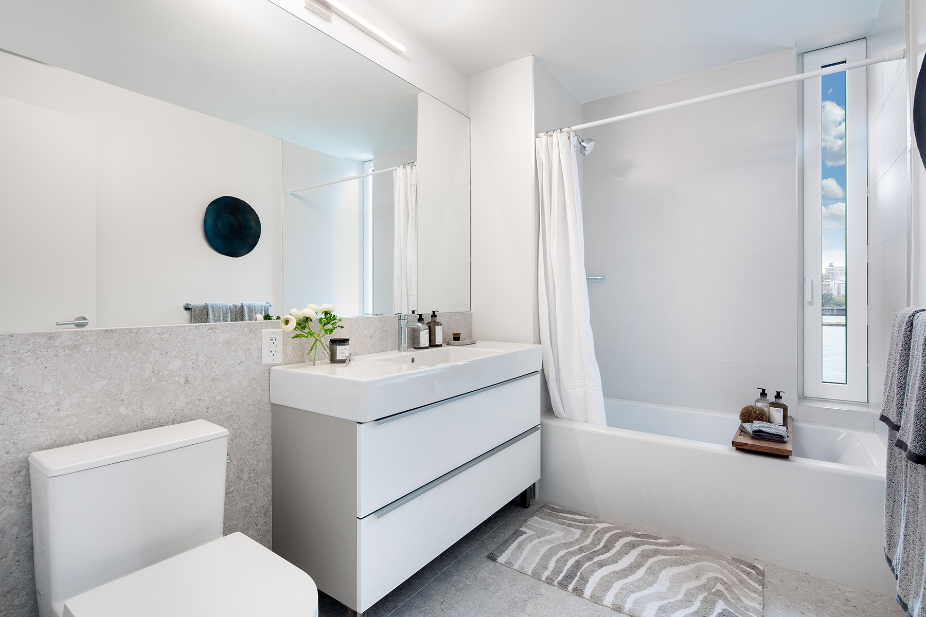 30-77 Vernon Boulevard, Unit PH811W Queens, NY 11102 - Photo 5 of 21 a bathroom with a sink mirror vanity and toilet