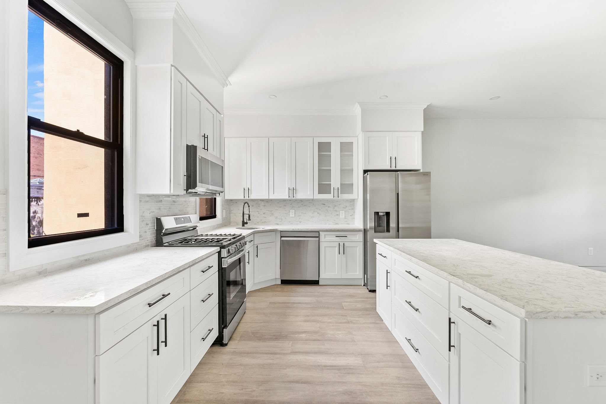 1414 30th Road Queens, NY 11102 - Photo 3 of 16 a kitchen with white cabinets sink and white appliances