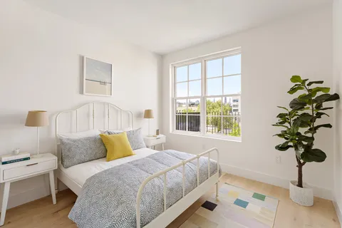 a bedroom with a bed lamp and window