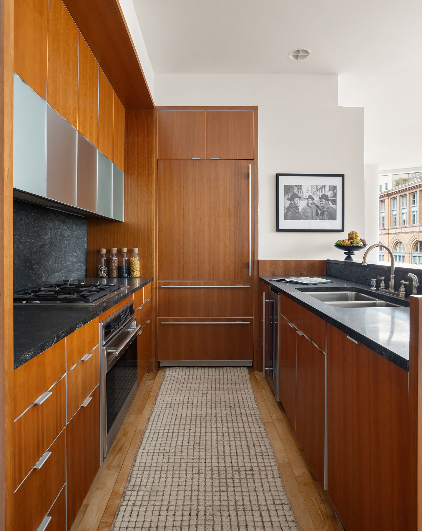 445 Lafayette Street, Unit 9C Manhattan, NY 10003 - Photo 4 of 10 a kitchen with granite countertop a sink stove and cabinets