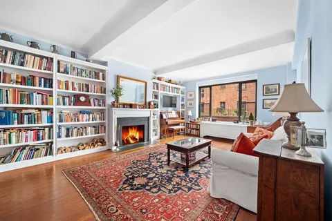 a living room with fireplace furniture and a book shelf
