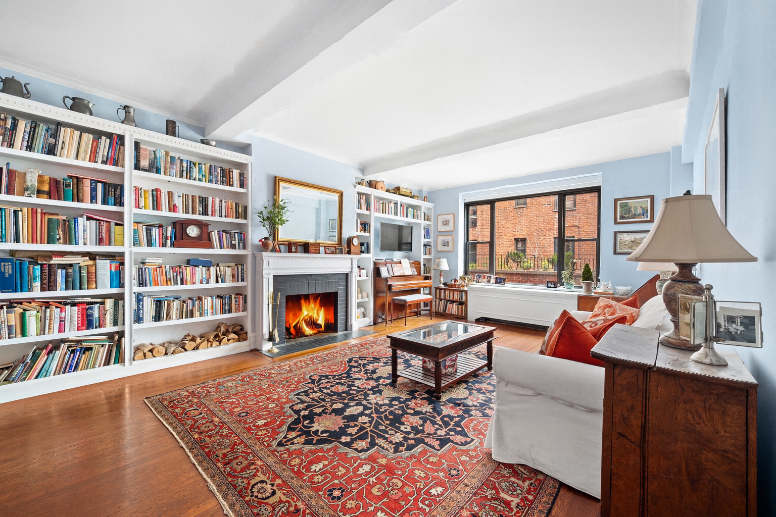 325 East 57th Street, Unit 11D Manhattan, NY 10022 - Photo 3 of 13 a living room with fireplace furniture and a book shelf