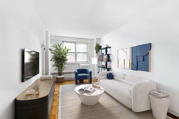a living room with furniture a flat screen tv and a window