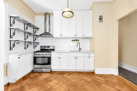 a kitchen with stainless steel appliances granite countertop a sink a stove a cabinets and a window