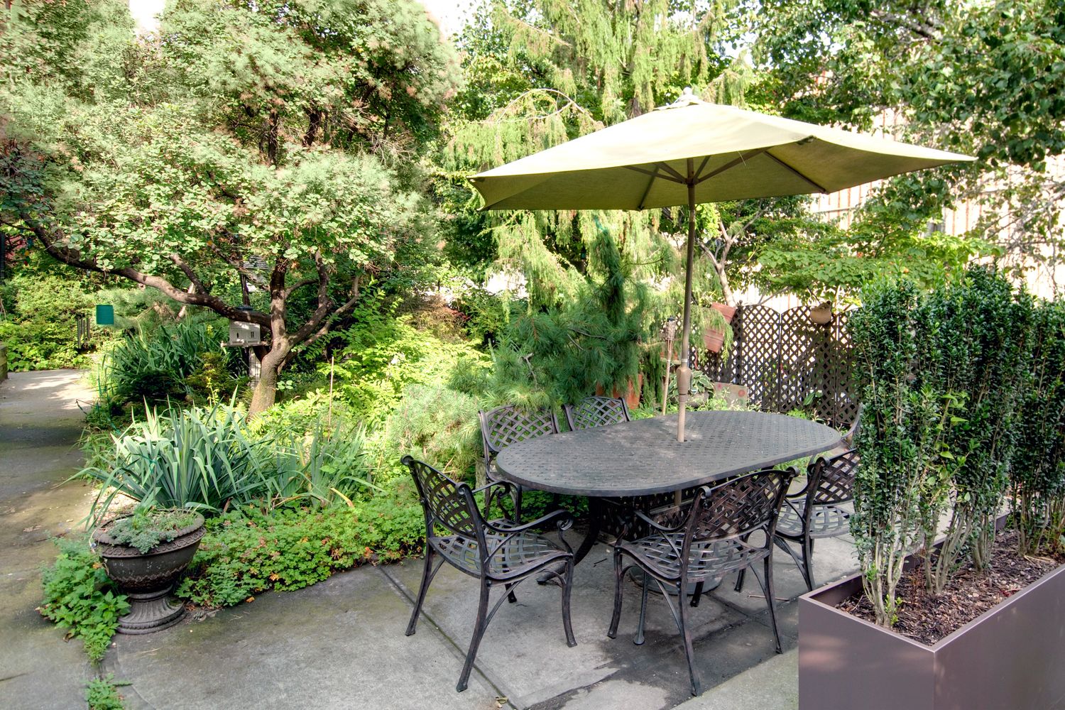 55 Poplar Street, Unit 6K Brooklyn, NY 11201 - Photo 14 of 15 a backyard of a house with table and chairs under an umbrella