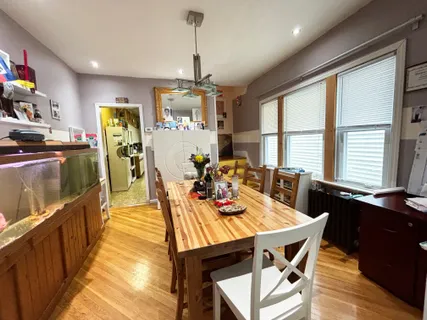 a view of a dining room and livingroom with furniture wooden floor a chandelier