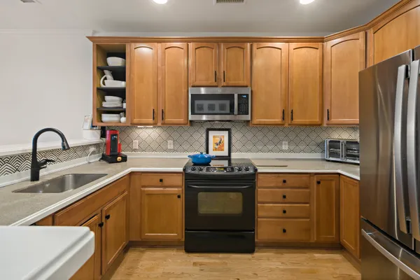 a kitchen with stainless steel appliances granite countertop a stove top oven a sink and dishwasher