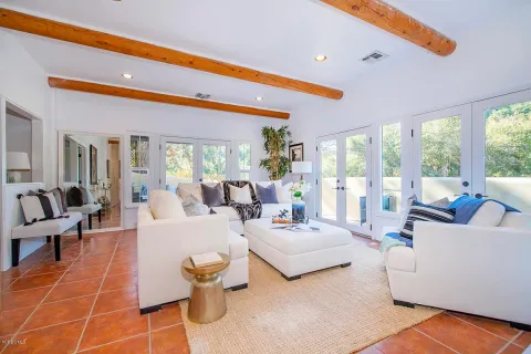 a living room with patio furniture and a large window