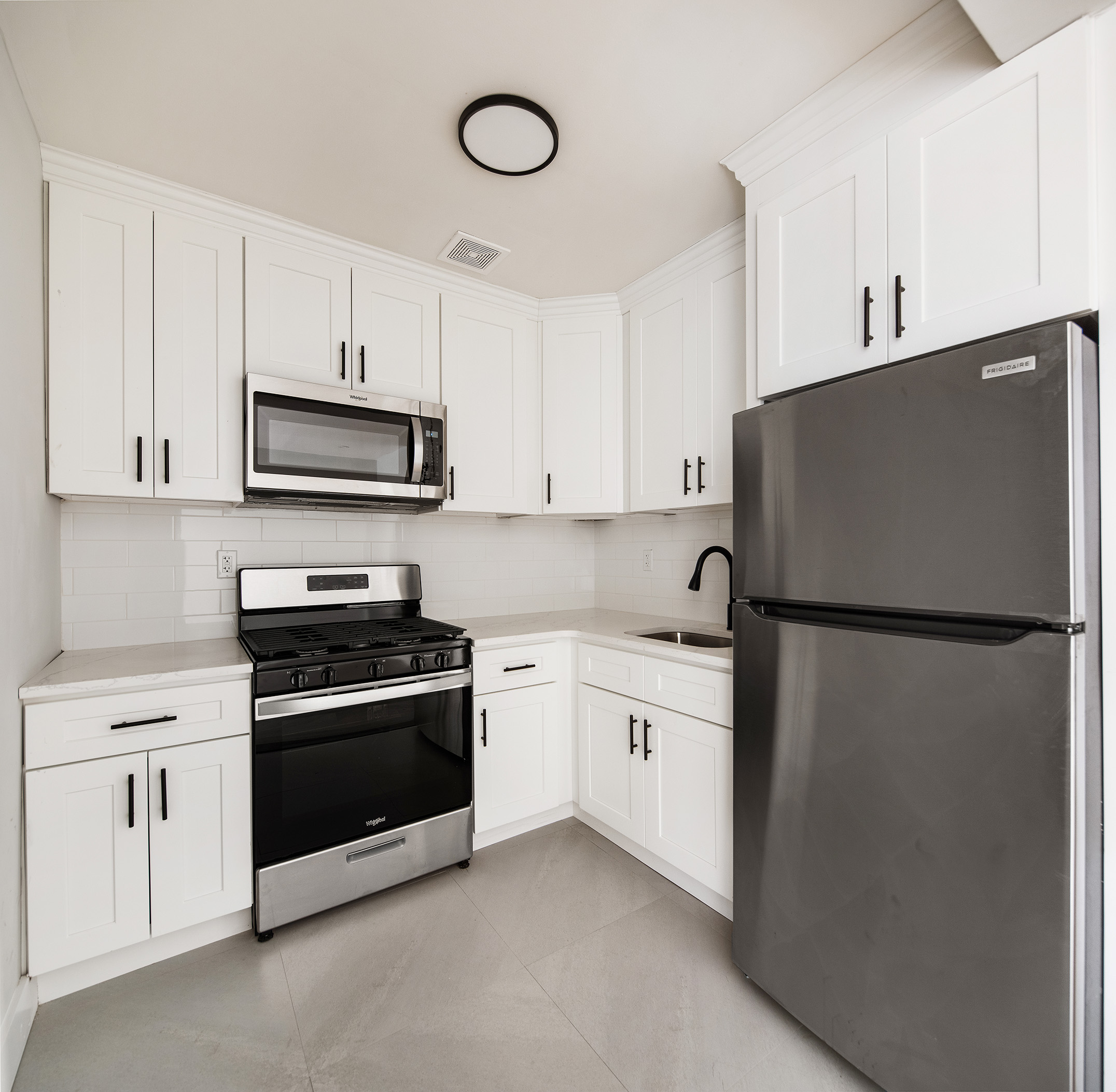 405 Herkimer Street, Unit 3 Brooklyn, NY 11213 - Photo 3 of 8 a kitchen with stainless steel appliances white cabinets and a refrigerator