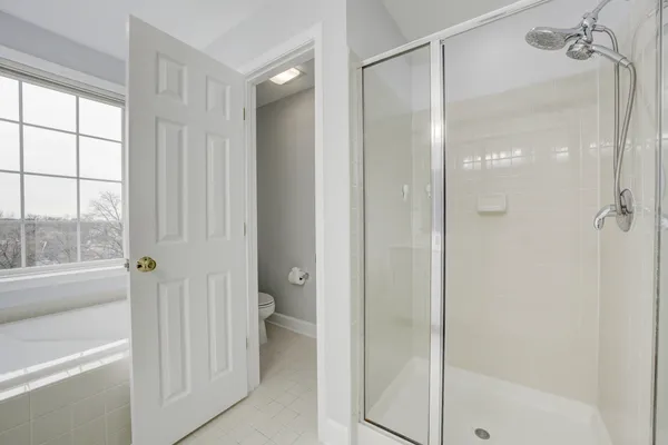 a bathroom with a glass shower door and a window