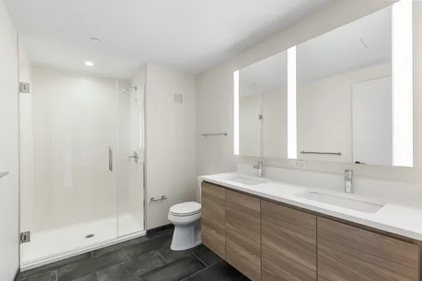a bathroom with a double vanity sink toilet and shower