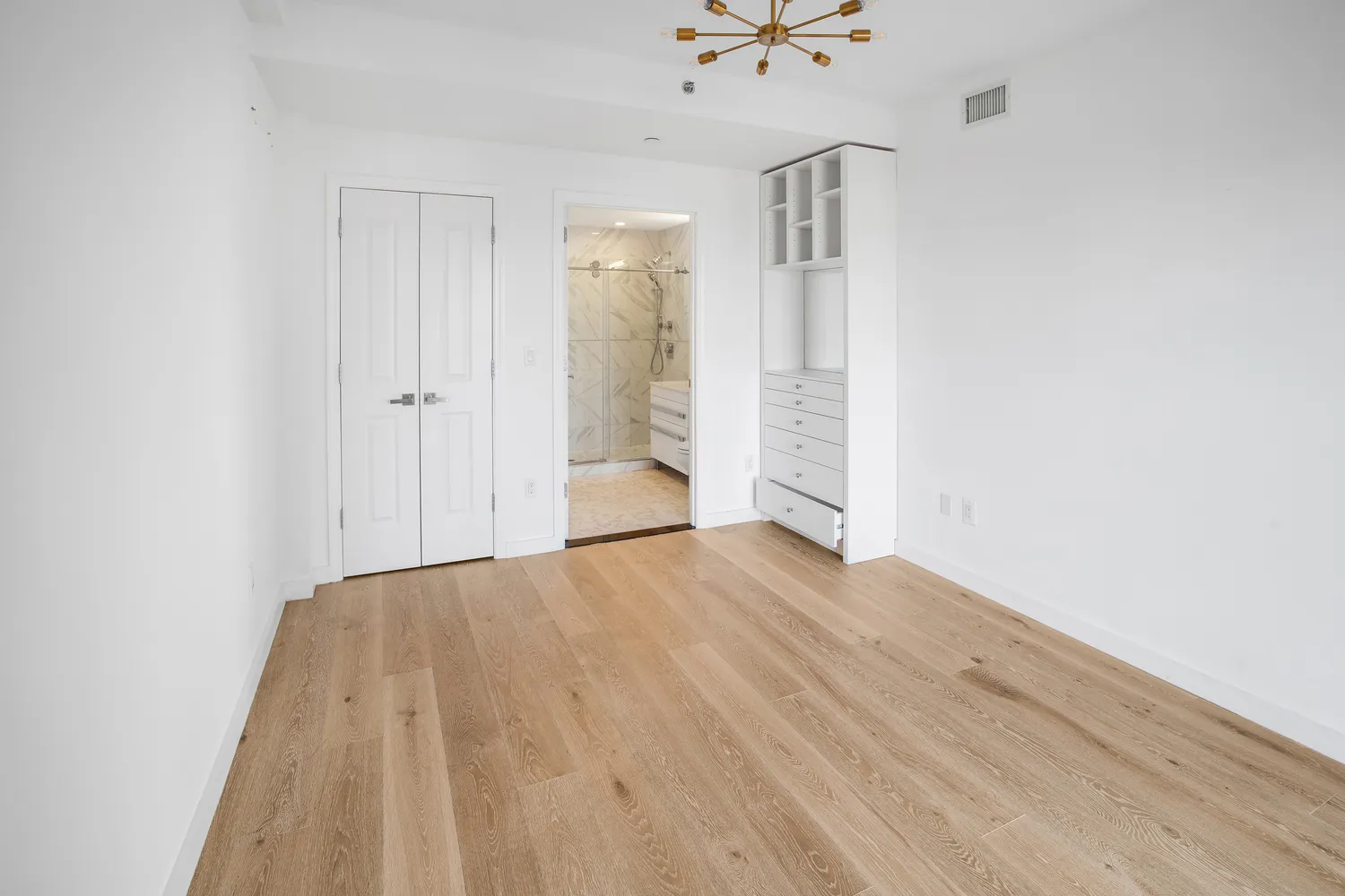 a view of empty room with wooden floor