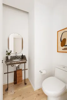 a bathroom with a toilet a sink and mirror