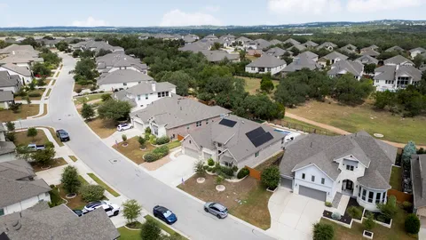 an aerial view of a house with outdoor space lake view and large trees