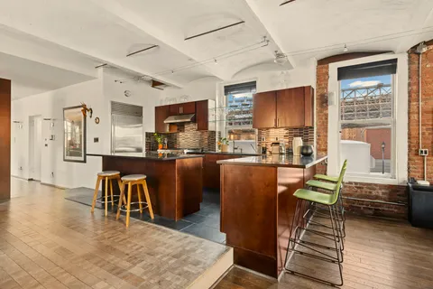 a living room with stainless steel appliances kitchen island granite countertop furniture and a kitchen view