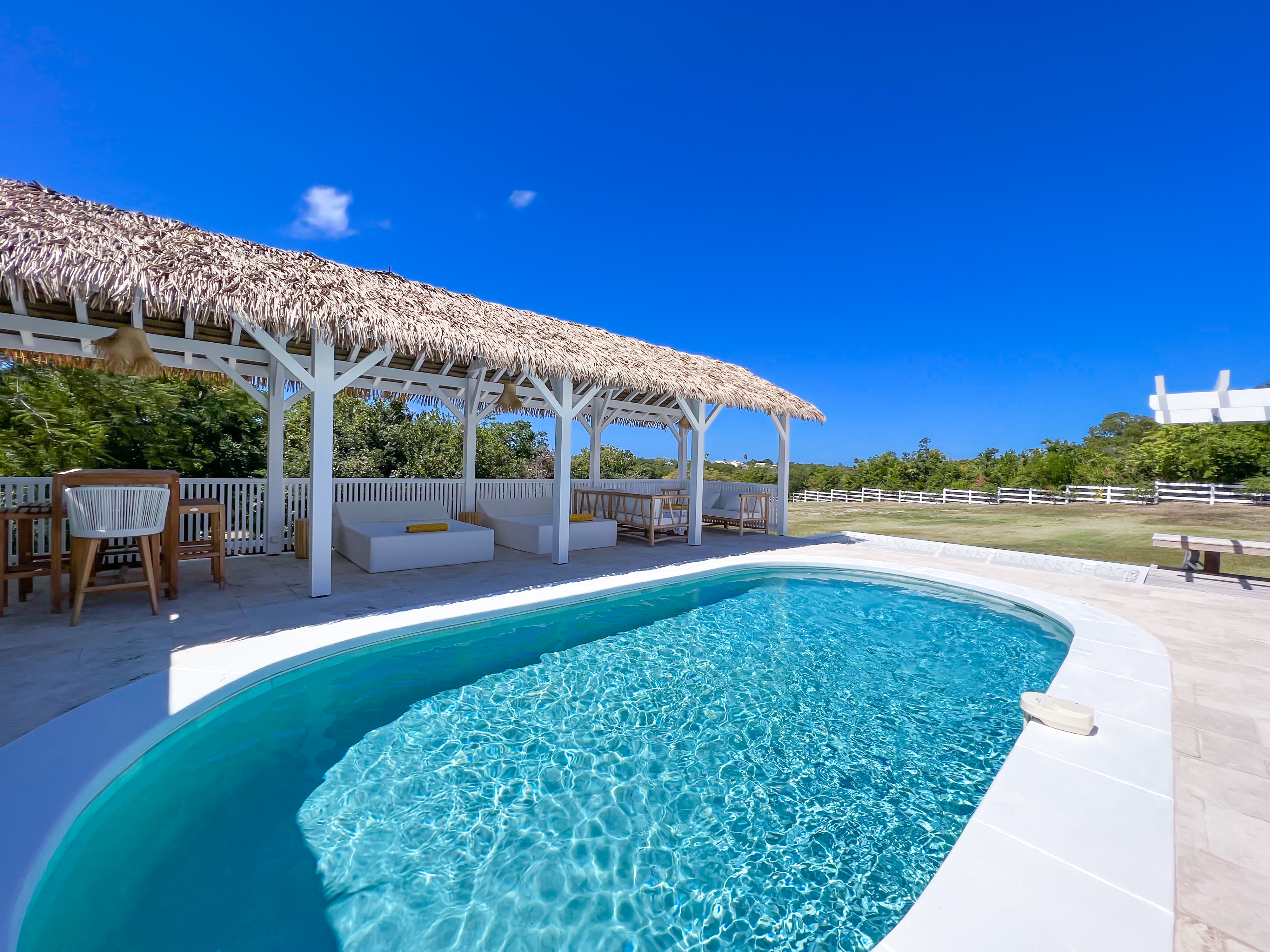 Terres Basses St. Martin, undefined 97150 - Photo 26 of 32 a view of a swimming pool with lawn chairs under an umbrella