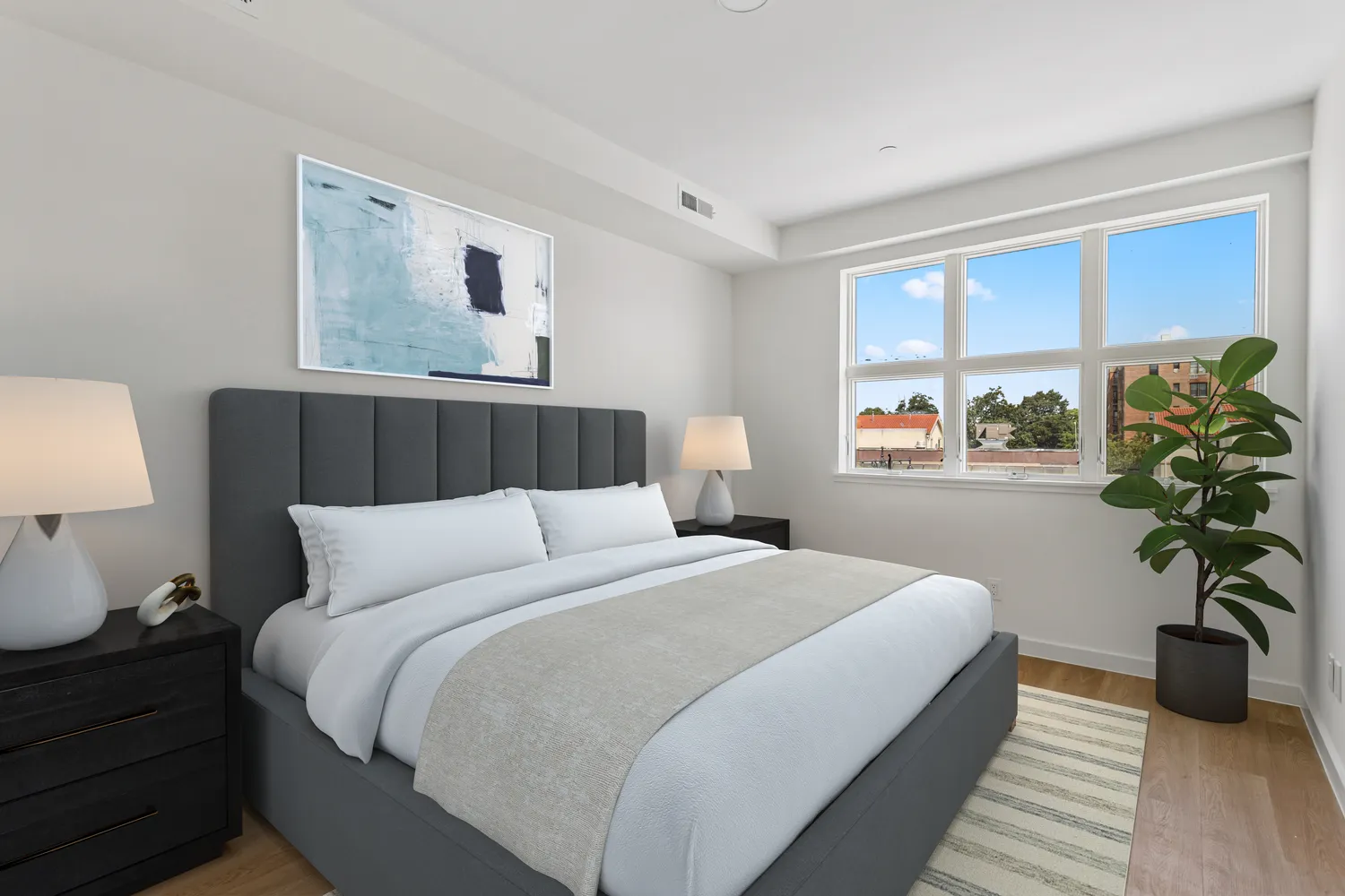 a bedroom with a large bed and a potted plant