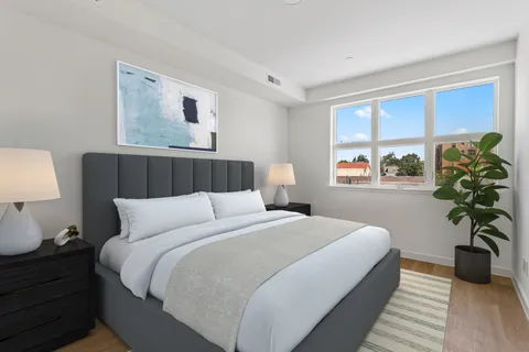 a bedroom with a large bed and a potted plant